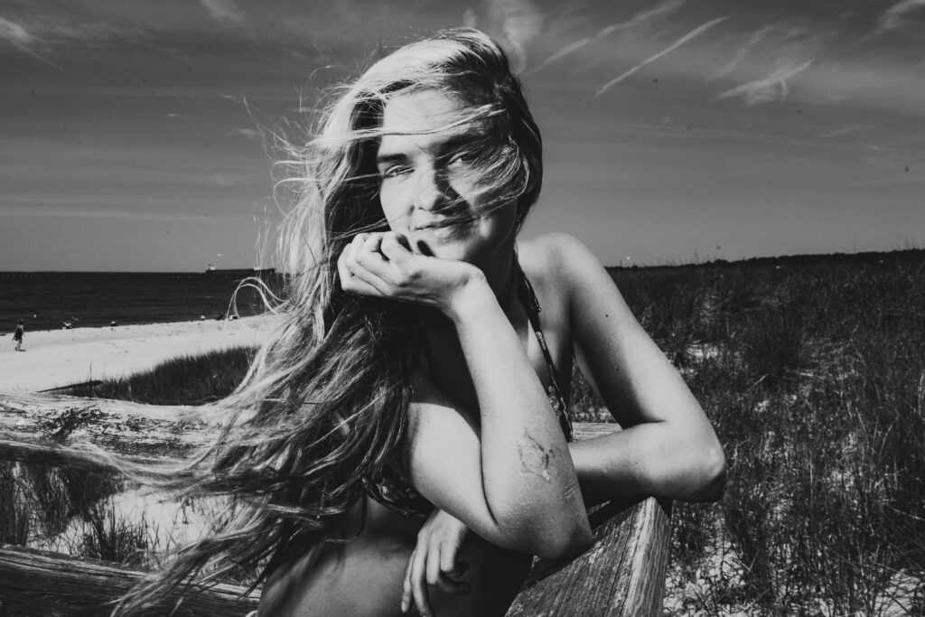 Black and white portrait of freelance model on Virginia Beach with windswept hair